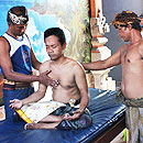Zwei schamanische Heiler führen eine Heilbehandlung an einem einheimischen Patienten durch.
